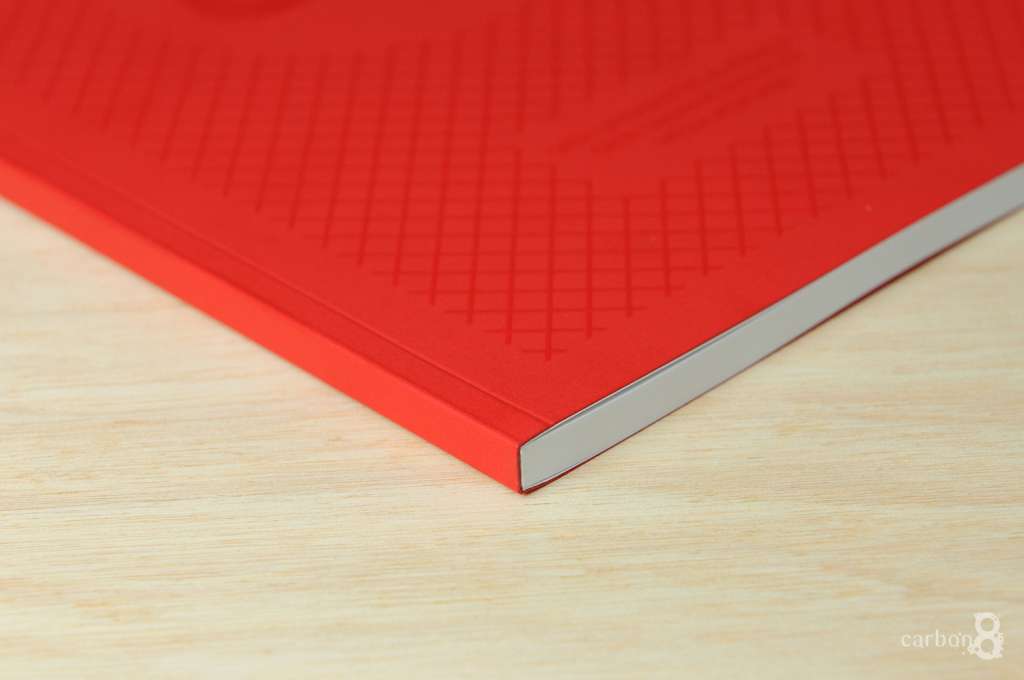 A red book is on a wooden tabletop