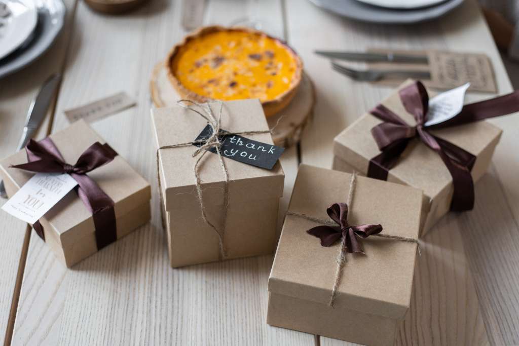 Some gift boxes, pies, cutlery are placed on the wooden tabletop