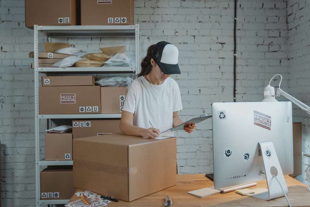 A woman writes on a box