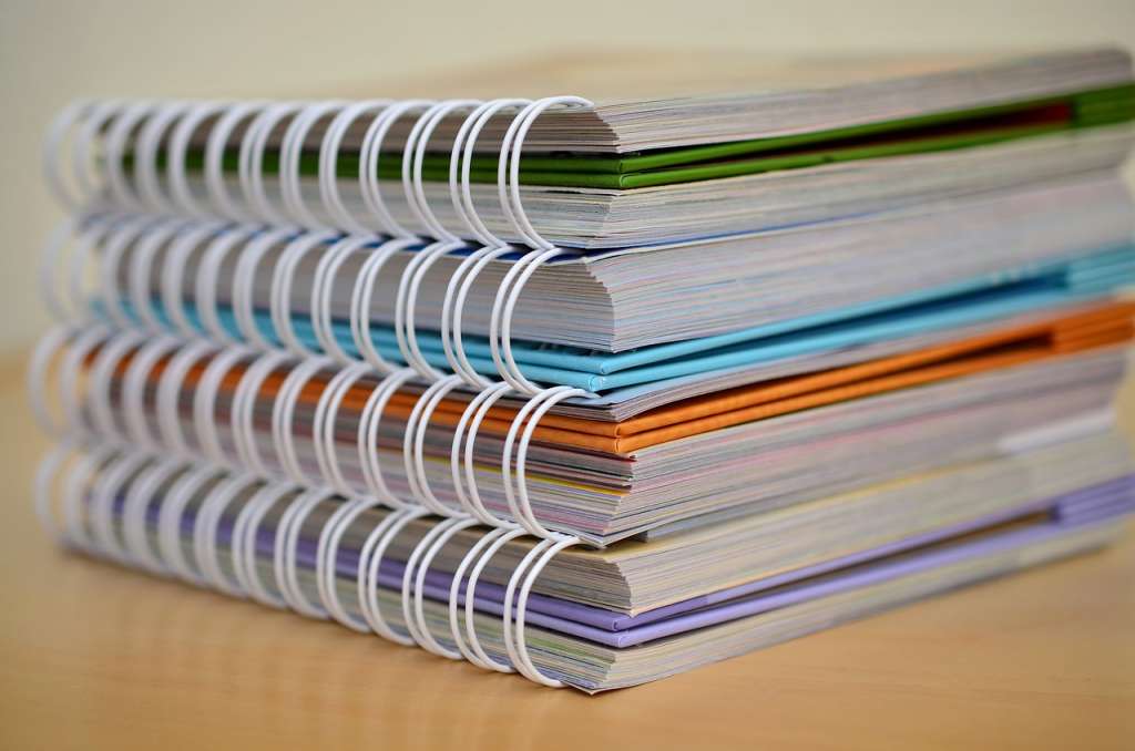 Four books stacked on wooden tabletop